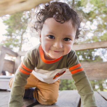 Toddler crawling on a deck