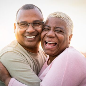 Man hugging woman while both laugh