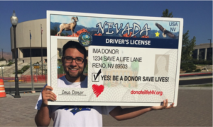 Man holding up drivers license sign with a red donor heart