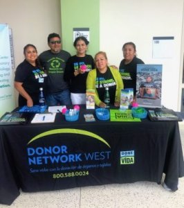 group of volunteers at a table offering information and swag