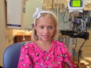 young girl smiling with hospital room background